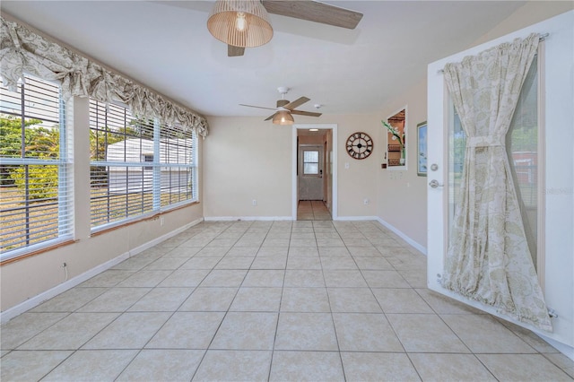 tiled spare room featuring ceiling fan