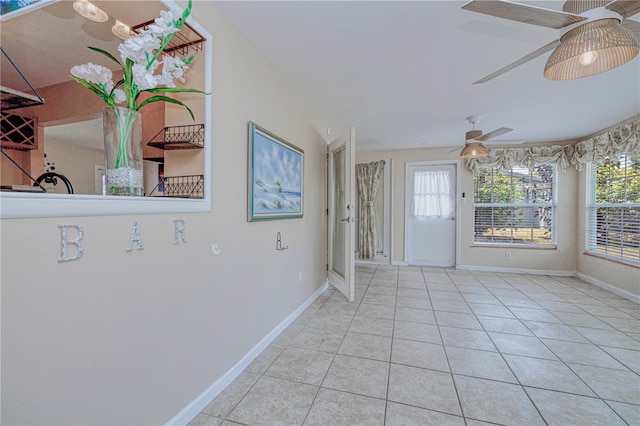 entrance foyer featuring ceiling fan, a healthy amount of sunlight, and light tile floors