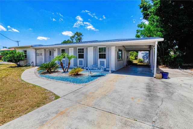 ranch-style home featuring a carport and a front lawn