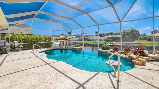 view of swimming pool featuring a patio area, a lanai, and a grill