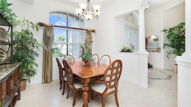 dining area featuring an inviting chandelier, a high ceiling, light tile floors, and decorative columns