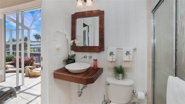 bathroom with sink, an enclosed shower, and toilet