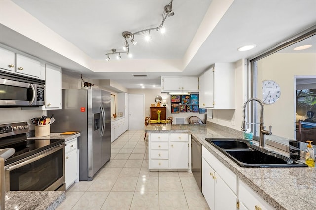 kitchen with light tile floors, sink, white cabinetry, a tray ceiling, and stainless steel appliances