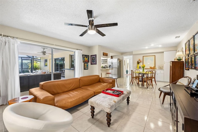 tiled living room with a textured ceiling and ceiling fan