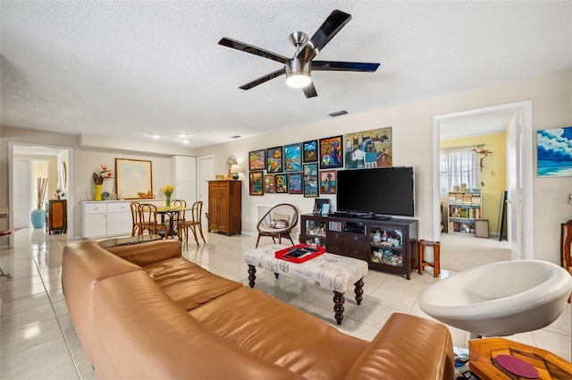 tiled living room featuring ceiling fan and a textured ceiling