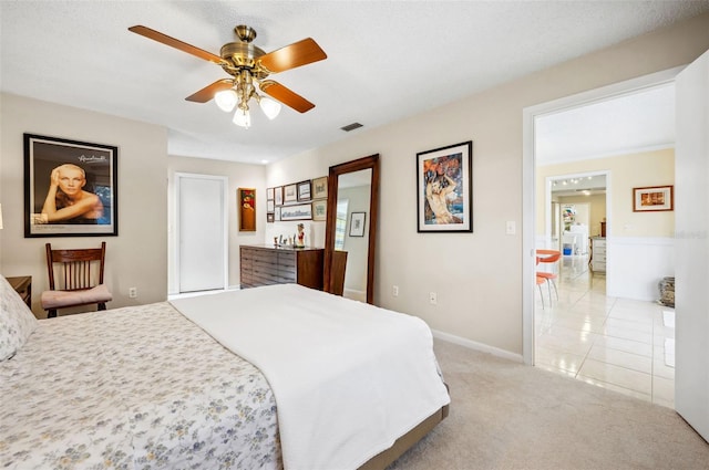 bedroom with light colored carpet, ceiling fan, and a textured ceiling