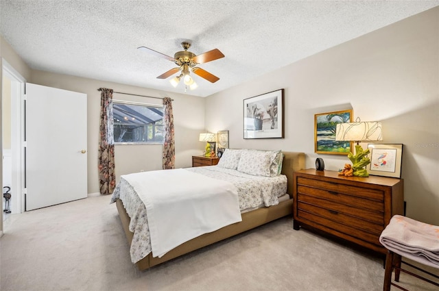 carpeted bedroom featuring a textured ceiling and ceiling fan