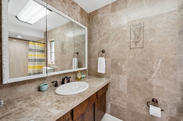 bathroom featuring tile walls, vanity, and backsplash