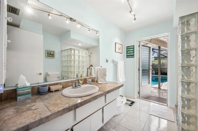 bathroom featuring walk in shower, large vanity, rail lighting, tile flooring, and toilet