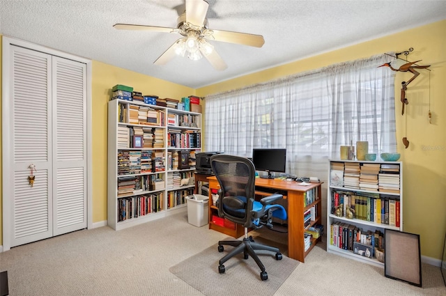 carpeted home office with ceiling fan and a textured ceiling