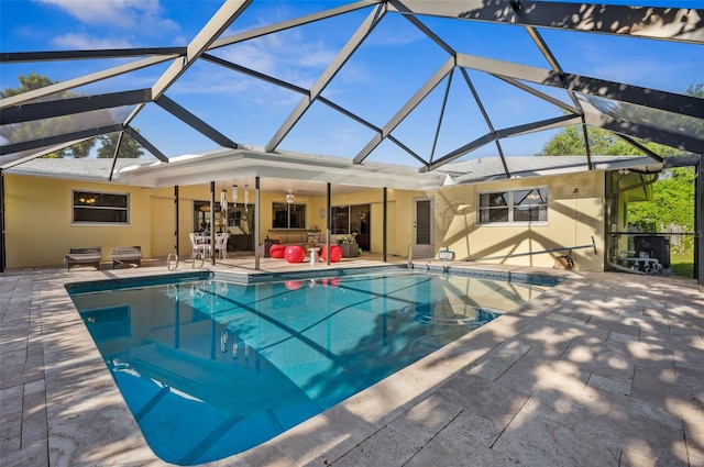 view of pool with glass enclosure and a patio area