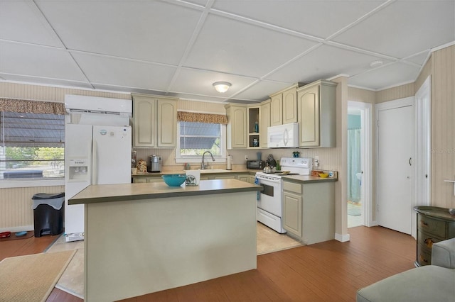 kitchen with a center island, sink, light hardwood / wood-style floors, white appliances, and an AC wall unit