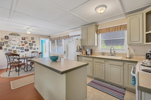 kitchen with white appliances, sink, a kitchen island, light hardwood / wood-style floors, and ceiling fan