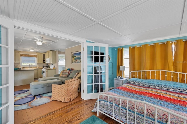 bedroom with hardwood / wood-style floors, sink, and ceiling fan