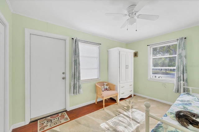 bedroom with wood-type flooring, ceiling fan, and crown molding