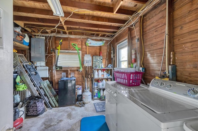 washroom with washing machine and dryer and wooden walls