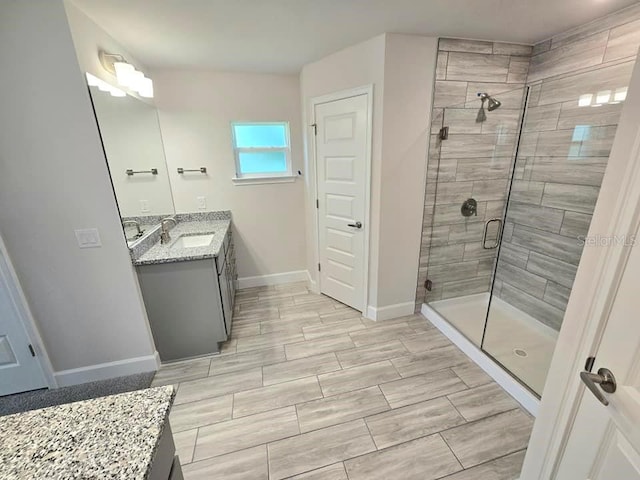 bathroom featuring vanity and a shower with door