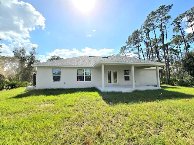 back of property with a lawn and a patio