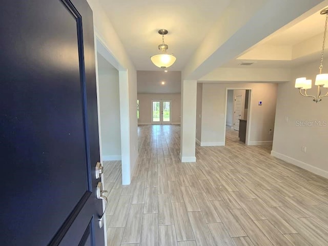 interior space featuring light wood-type flooring and an inviting chandelier