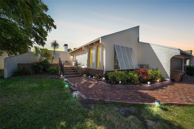 exterior space featuring a patio area, a yard, and central AC