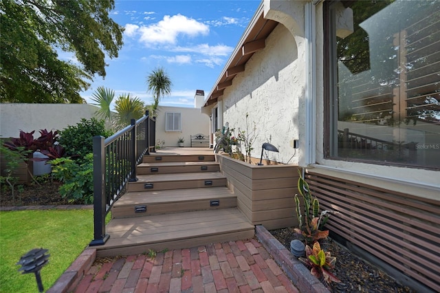 wooden terrace featuring a lawn