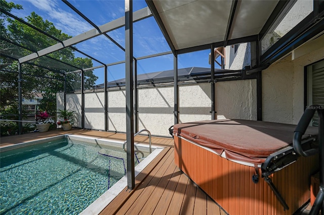 view of pool with a covered hot tub and glass enclosure