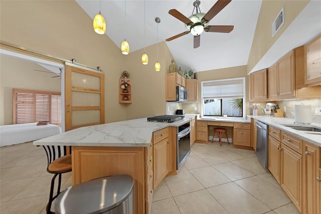 kitchen with appliances with stainless steel finishes, tasteful backsplash, light tile floors, and a kitchen breakfast bar