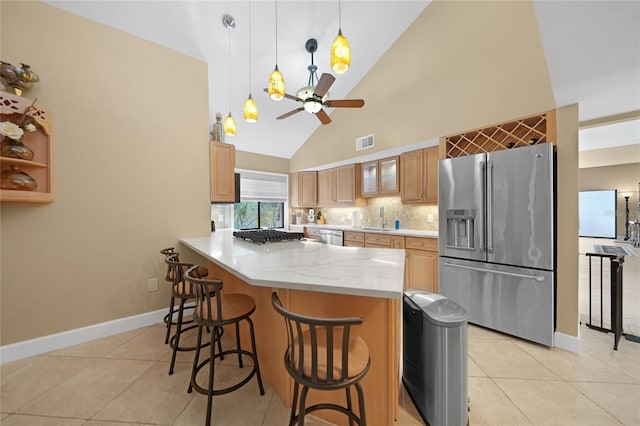 kitchen with a kitchen breakfast bar, pendant lighting, sink, stainless steel fridge with ice dispenser, and ceiling fan