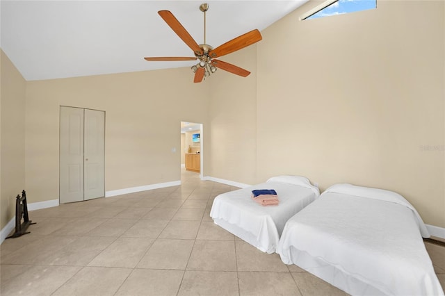 bedroom with a closet, high vaulted ceiling, ceiling fan, and light tile floors