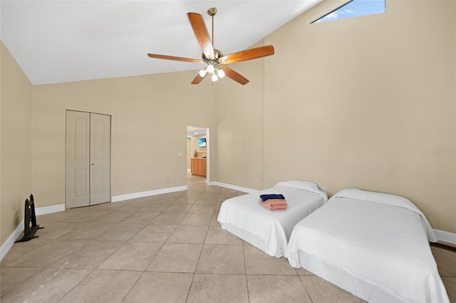 tiled bedroom featuring a closet, high vaulted ceiling, and ceiling fan