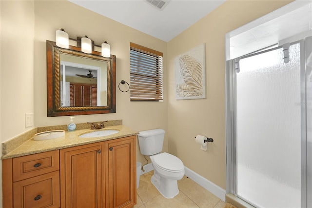 bathroom featuring tile flooring, ceiling fan, toilet, a shower with shower door, and vanity