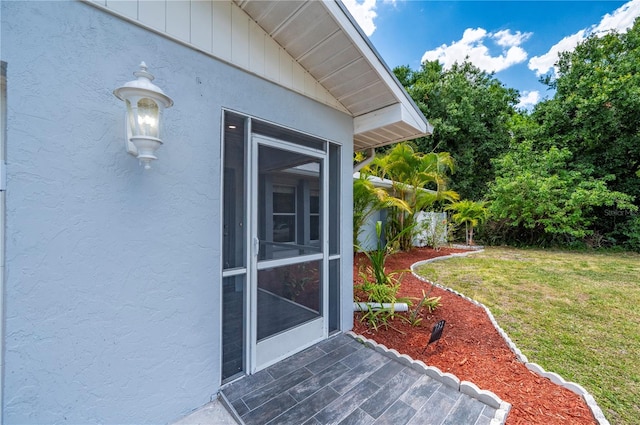 doorway to property with a lawn