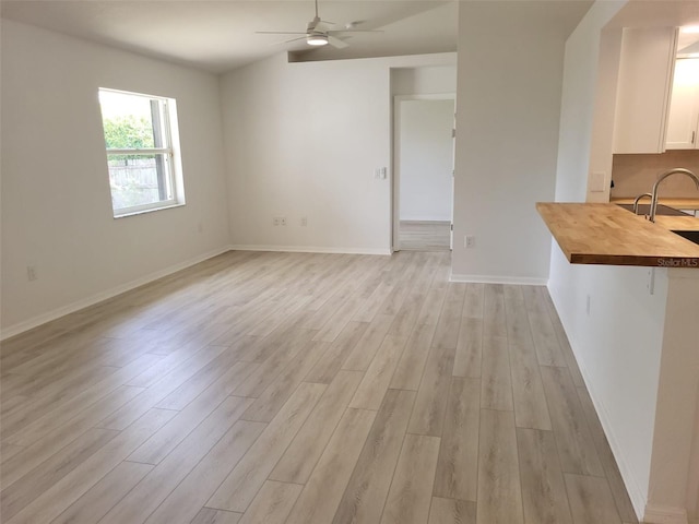 unfurnished dining area with ceiling fan and light hardwood / wood-style floors