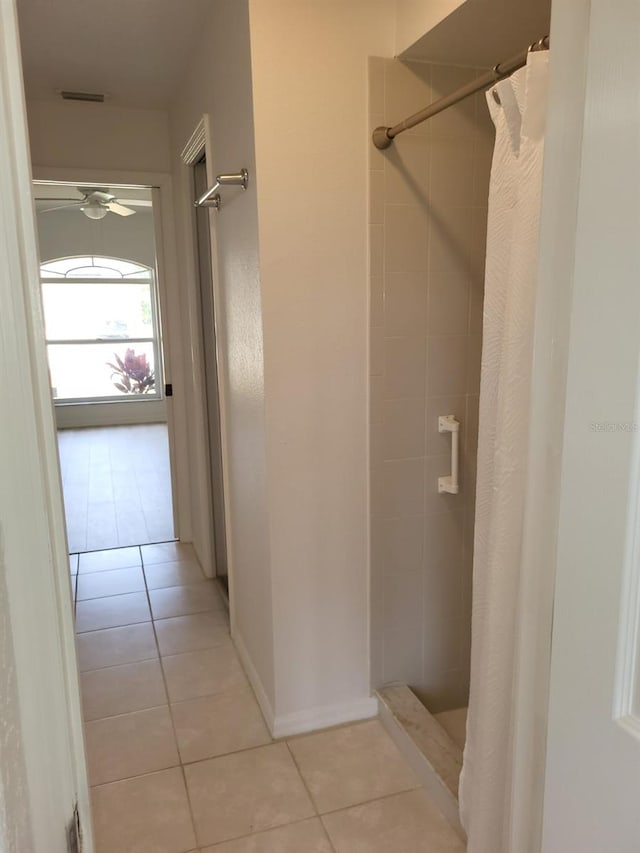 bathroom with tile flooring, ceiling fan, and a shower with curtain