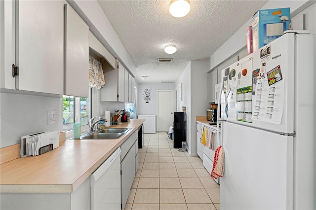 kitchen with light tile floors, a textured ceiling, sink, white appliances, and gray cabinetry