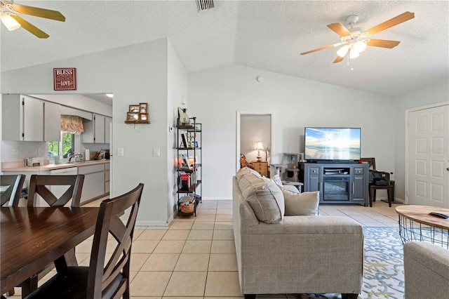 tiled living room featuring lofted ceiling, ceiling fan, and a textured ceiling