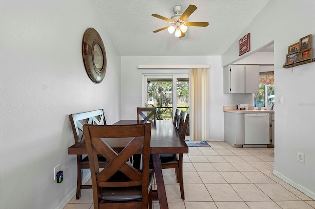 tiled dining area featuring a healthy amount of sunlight, a textured ceiling, and ceiling fan