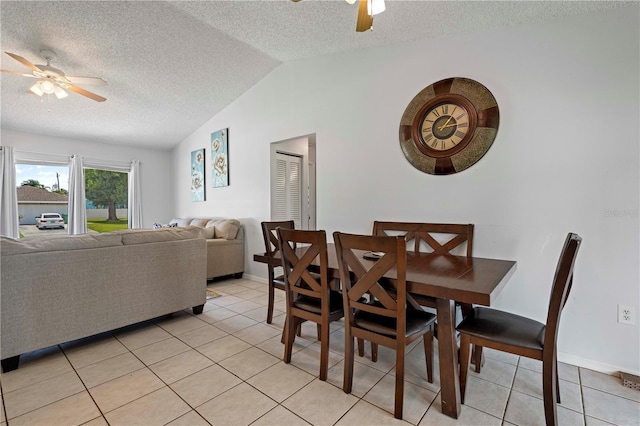 tiled dining space featuring a textured ceiling, ceiling fan, and vaulted ceiling