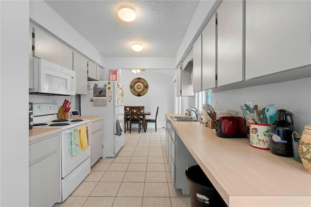 kitchen with gray cabinetry, white appliances, a textured ceiling, sink, and light tile floors