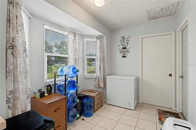 washroom featuring a textured ceiling and light tile floors