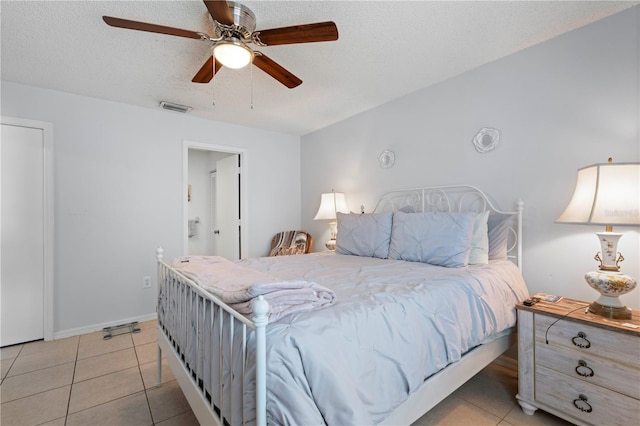 tiled bedroom featuring a textured ceiling and ceiling fan