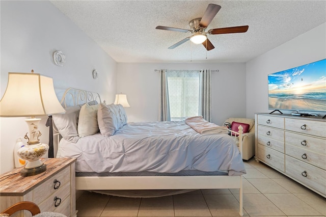 tiled bedroom with ceiling fan and a textured ceiling