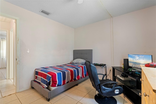 tiled bedroom featuring a textured ceiling