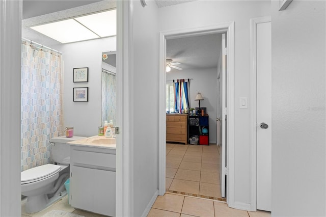 bathroom with ceiling fan, toilet, tile flooring, a textured ceiling, and vanity