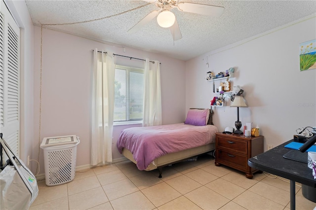 tiled bedroom featuring a closet, ceiling fan, and a textured ceiling