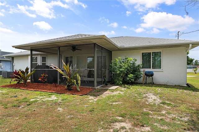 back of property featuring central AC, ceiling fan, a yard, and a sunroom