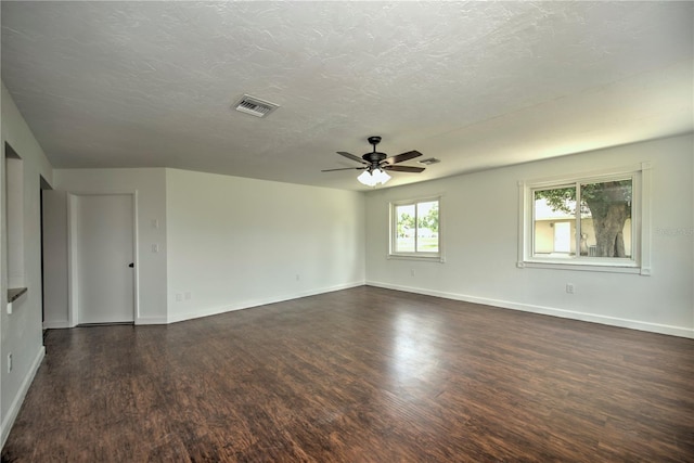 empty room with dark hardwood / wood-style floors, ceiling fan, and a textured ceiling