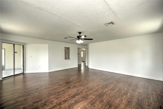 spare room featuring dark hardwood / wood-style flooring, ceiling fan, and a textured ceiling