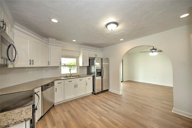 kitchen featuring light hardwood / wood-style flooring, stainless steel appliances, tasteful backsplash, white cabinetry, and sink