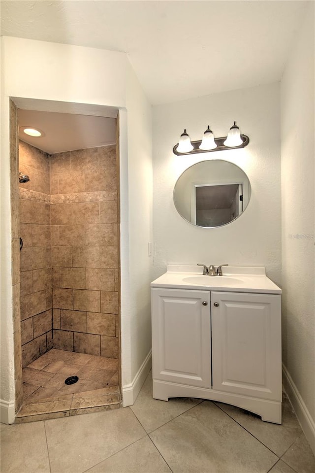 bathroom featuring tiled shower, tile floors, and vanity